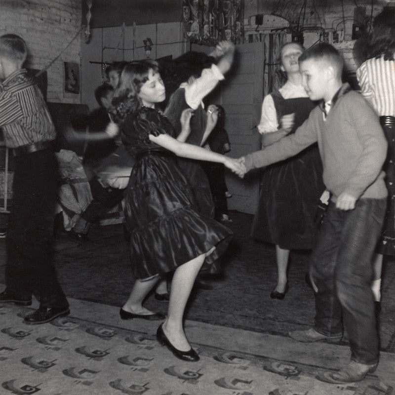 Black and white vintage photograph of a boy and girl dancing with school friends