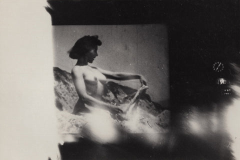 Black and white vintage photo of a nude woman in a grindhouse theatre screen