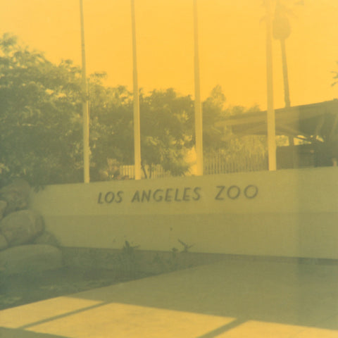 Bright yellow and green hued vintage photograph of the entrance to the Los Angeles Zoo