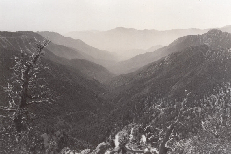 Black and white vintage photo of layers of mountains, fading into the distance